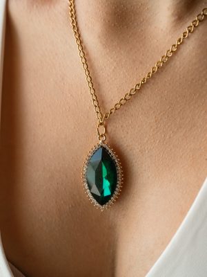Ένα εκθαμβωτικό κολιέ με βαθυπράσινο μαρκαζίτ κρύσταλλο σε σχήμα αμυγδάλου, περιτριγυρισμένο από μικροσκοπικές λαμπερές πέτρες τύπου ζιργκόν. Πάνω σε ατσάλινη αλυσίδα.