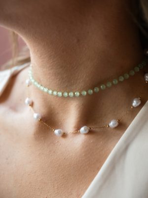 Δροσερό και ρομαντικό με ημιδιάφανες, ανοιχτοπράσινες χάντρες που αποπνέουν φρεσκάδα και νεανικότητα. Ενώ στο κάτω μέρος φυσικές λευκές πέρλες, αραιά τοποθετημένες σε λεπτή χρυσή αλυσίδα.