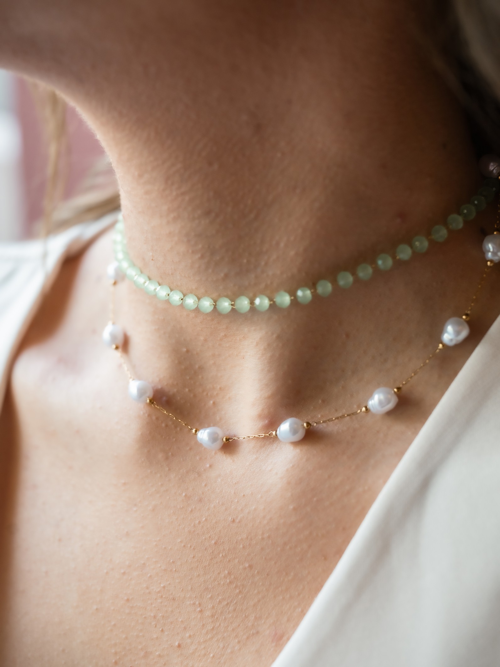 Δροσερό και ρομαντικό με ημιδιάφανες, ανοιχτοπράσινες χάντρες που αποπνέουν φρεσκάδα και νεανικότητα. Ενώ στο κάτω μέρος φυσικές λευκές πέρλες, αραιά τοποθετημένες σε λεπτή χρυσή αλυσίδα.