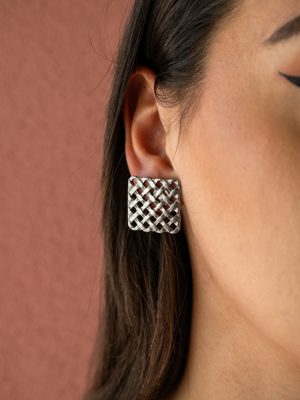 Τα ”Woven Steel” είναι statement σκουλαρίκια που εντυπωσιάζουν με το ιδιαίτερο, πλεχτό-γεωμετρικό μοτίβο τους. Κατασκευασμένα από ασημί ατσάλι με ματ φινίρισμα, θυμίζουν την αυστηρότητα του σχήματος με την ελαφριά αίσθηση μιας υφής.