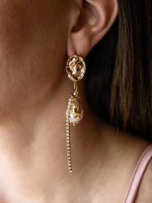 Ανάγλυφη φιγούρα με μαργαριτάρι διακοσμημένο με χρυσό φύλλωμα και μια γραμμή από αστραφτερά στρας.