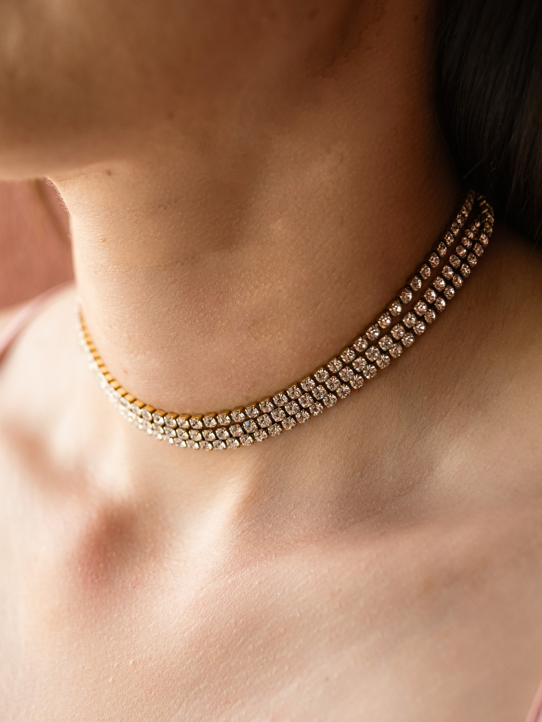 Πρόκειται για ένα τριπλό choker με τρείς σειρές από εκθαμβωτικά στρας, τοποθετημένα σε λεπτή χρυσή βάση που αγκαλιάζει τέλεια τον λαιμό.