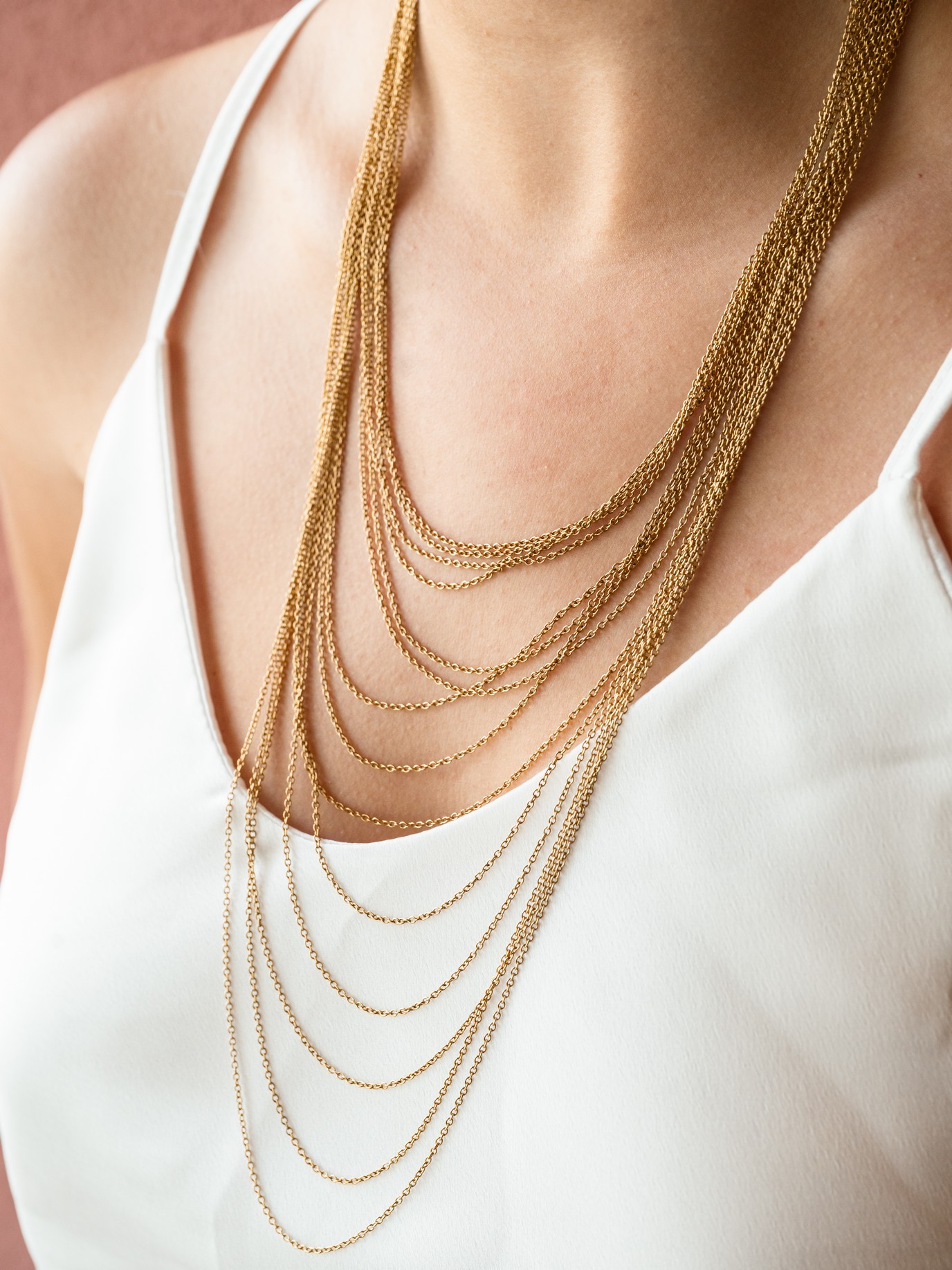 Αποτελείται από λεπτές χρυσές αλυσίδες διαφορετικών μήκων, οι οποίες πέφτουν σε καμπύλες και δημιουργούν ένα ρευστό, ”βελοειδές” αποτέλεσμα που αγκαλιάζει απαλά το ντεκολτέ.