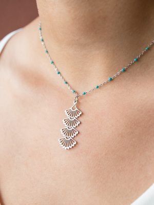 Ανάλαφρο και ρομαντικό κολιέ. Από λεπτή αλυσίδα με μικρές τιρκουάζ χάντρες που αγκαλιάζουν όμορφα τον λαιμό. Με κρεμαστό στοιχείο σε σχήμα βεντάλια.