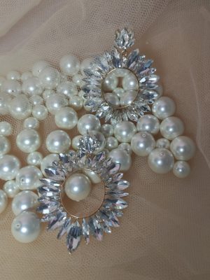 Λαμπερά σκουλαρίκια σε σχέδιο ήλιου με διαφανείς κρυστάλλους. Ακτινοβολούν κομψότητα και φώς.