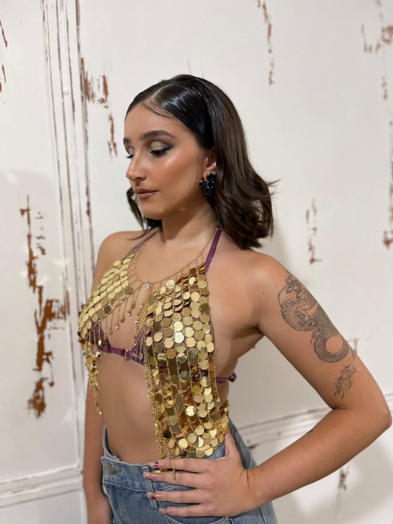 Λαμπερό halter bra-top διακοσμημένο με χρυσές παγιέτες – κρύσταλλα που προσφέρουν μοναδική κίνηση και λάμψη σε κάθε βήμα. Ένα εντυπωσιακό κομμάτι.